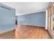 Bright living room with wood flooring, large window, and blue-grey walls offers a comfortable gathering space at 2823 Tulip Dr, Indianapolis, IN 46227