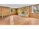 Living room featuring a stone fireplace, wood paneling, and wood-look flooring at 2823 Tulip Dr, Indianapolis, IN 46227