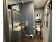 Neutral bathroom with a glass enclosed shower, dark wood flooring, and white storage cabinet at 3054 Ruckle St, Indianapolis, IN 46205