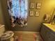 Decorated bathroom with floral shower curtain, decorative prints, and matching toilet seat and rugs at 3054 Ruckle St, Indianapolis, IN 46205