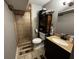 A bathroom featuring a tiled shower, dark wood vanity, and matching decorative accents at 3054 Ruckle St, Indianapolis, IN 46205
