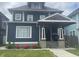 Charming two-story home with a covered front porch, neat landscaping, and a blue exterior at 3054 Ruckle St, Indianapolis, IN 46205