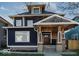 Beautiful two story home features a dark blue exterior, stone accents, covered porch, and well-maintained landscaping at 3054 Ruckle St, Indianapolis, IN 46205
