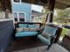 Relaxing front porch featuring a bench, chair, and table decorated with light blue cushions and pillows with floral prints at 3054 Ruckle St, Indianapolis, IN 46205