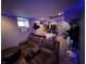 Living room featuring exposed utilities, ambient blue lighting, and comfortable seating at 3054 Ruckle St, Indianapolis, IN 46205