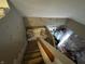 View of the staircase with carpeted steps leading to a cozy room with a white loveseat and storage containers at 3054 Ruckle St, Indianapolis, IN 46205