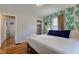 Cozy bedroom featuring an accent wall with leafy wallpaper and hardwood floors at 315 W 43Rd St, Indianapolis, IN 46208