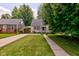 Well-maintained front lawn of a home featuring a concrete walkway and mature trees at 315 W 43Rd St, Indianapolis, IN 46208