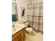 Bathroom featuring wood vanity, sink, toilet, and a shower with striped curtain at 3418 S Rosewind Dr, New Palestine, IN 46163