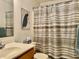 Cozy bathroom featuring a sink, toilet, striped shower curtain, and peacock wall art at 3418 S Rosewind Dr, New Palestine, IN 46163