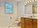 Bright bathroom with a vanity, toilet, window, and tile floors at 3418 S Rosewind Dr, New Palestine, IN 46163