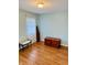Small bedroom with hardwood floors, window, bench, and dresser at 3418 S Rosewind Dr, New Palestine, IN 46163