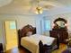 Comfortable bedroom with wooden floors, ceiling fan, bathroom entrance and antique vanity at 3418 S Rosewind Dr, New Palestine, IN 46163