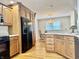 Well-equipped kitchen features light oak cabinets, black appliances, and a view into the dining area at 3418 S Rosewind Dr, New Palestine, IN 46163