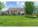 Backyard featuring a lush lawn, pergola over a patio with seating, a hot tub, and mature trees at 3420 Stoddard Pl, Indianapolis, IN 46217