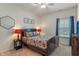 Cozy bedroom featuring a queen-sized bed with a floral comforter, carpeted floors and natural light from the window at 3420 Stoddard Pl, Indianapolis, IN 46217