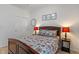 Comfortable bedroom with a queen bed, floral bedding, bedside lamps, closet, and carpeted floors at 3420 Stoddard Pl, Indianapolis, IN 46217