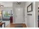 Bright entryway with hardwood floors, white door, coat hooks, and view into a living room with plenty of natural light at 3420 Stoddard Pl, Indianapolis, IN 46217