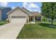 Charming home featuring a well-manicured lawn, light brick facade, and a welcoming front porch seating area at 3420 Stoddard Pl, Indianapolis, IN 46217
