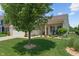 Beautifully landscaped front yard featuring a manicured lawn, decorative trees, and a charming entrance with bench seating at 3420 Stoddard Pl, Indianapolis, IN 46217