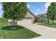 A well kept light brick home features a two car garage, long driveway, and mature trees in a community at 3420 Stoddard Pl, Indianapolis, IN 46217