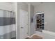 Hallway leading to a walk-in closet with built-in shelving and a bathroom with a shower and neutral walls at 3420 Stoddard Pl, Indianapolis, IN 46217