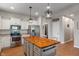 Bright kitchen features white cabinets, stainless appliances, and a butcher block island with pendant lighting at 3420 Stoddard Pl, Indianapolis, IN 46217