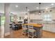Bright, open concept kitchen with island seating, white cabinets, modern lighting, and flows to the living space at 3420 Stoddard Pl, Indianapolis, IN 46217