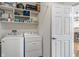 Well-organized laundry room equipped with modern washer and dryer, shelving, and a conveniently located door at 3420 Stoddard Pl, Indianapolis, IN 46217