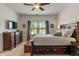 Serene primary bedroom with a large window, dark wood furnishings, and a ceiling fan at 3420 Stoddard Pl, Indianapolis, IN 46217