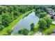 Panoramic aerial shot of a pond surrounded by trees and neighborhood homes at 369 Rodeo Dr, Indianapolis, IN 46217
