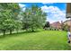 Expansive green backyard with mature trees and view of a lake at 369 Rodeo Dr, Indianapolis, IN 46217