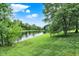 Picturesque pond surrounded by mature trees and lush green grass at 369 Rodeo Dr, Indianapolis, IN 46217