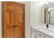 Bathroom featuring vanity with matte black fixtures and wood grain closet doors at 369 Rodeo Dr, Indianapolis, IN 46217