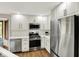 Bright kitchen boasts white cabinets, stainless steel appliances, quartz countertops, and stylish subway tile at 369 Rodeo Dr, Indianapolis, IN 46217