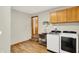 Functional laundry room equipped with modern washer and dryer, sink, and storage cabinets at 369 Rodeo Dr, Indianapolis, IN 46217