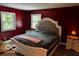 Stylish bedroom featuring red walls, carpet, a decorative headboard, and natural light at 3815 Briar Rdg, Monrovia, IN 46157