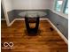 Dining room featuring hardwood floors, two-tone walls, and a glass-top dining table at 3815 Briar Rdg, Monrovia, IN 46157