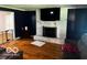 Comfortable living room with a white brick fireplace, hardwood floors, and dark accent walls at 3815 Briar Rdg, Monrovia, IN 46157