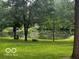 Beautiful view of a tranquil pond surrounded by mature trees and lush lawn at 3815 Briar Rdg, Monrovia, IN 46157