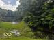 Picturesque view of a tranquil pond surrounded by lush greenery and trees at 3815 Briar Rdg, Monrovia, IN 46157