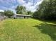 A spacious backyard with a large lawn, trees, and privacy fence at 4405 Phoenix Dr, Indianapolis, IN 46241