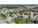 A charming neighborhood is seen from above, highlighting tree-lined streets and community water feature at 4465 W Woodbridge Ln, New Palestine, IN 46163