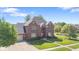 Stunning aerial view of the brick home showcasing its beautiful curb appeal and well-kept lawn at 4465 W Woodbridge Ln, New Palestine, IN 46163