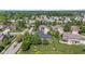 An aerial perspective of residential properties shows established landscaping, lush green lawns, and surrounding mature trees at 4465 W Woodbridge Ln, New Palestine, IN 46163