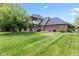 Spacious backyard featuring manicured lawn and a brick exterior with a screened-in porch at 4465 W Woodbridge Ln, New Palestine, IN 46163