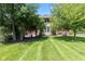 Spacious backyard with lush green grass and mature trees provides a serene outdoor space at 4465 W Woodbridge Ln, New Palestine, IN 46163