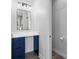 Modern bathroom with toilet room, sleek mirror, and dark blue cabinets at 4465 W Woodbridge Ln, New Palestine, IN 46163