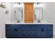 Bathroom featuring navy cabinets, double sinks, and a tall medicine cabinet at 4465 W Woodbridge Ln, New Palestine, IN 46163
