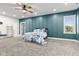 Bedroom with striking teal accent wall and lots of natural light at 4465 W Woodbridge Ln, New Palestine, IN 46163